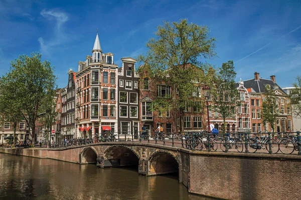 运河上的桥梁与砖建筑和人在阿姆斯特丹 — 图库照片