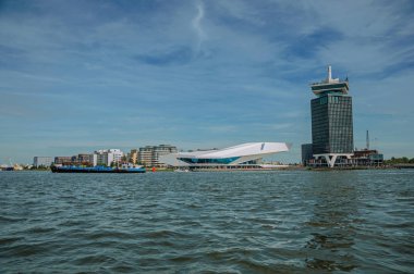 Amsterdam kanalı üzerinde gemi ve modern binalar