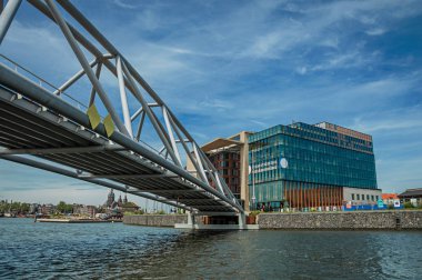 Amsterdam'da güneşli mavi gökyüzü altında bina ve demir köprü