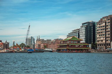 Amsterdam'da kanal kıyısında modern binalar ile Liman
