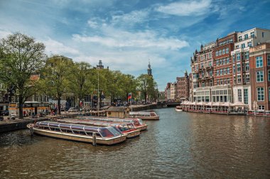 Amsterdam'da tuğla bina ve demirli tekneler ile Kanal