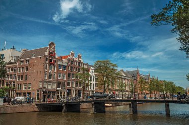 Amsterdam'da tuğla binalar ve köprü ile Kanal