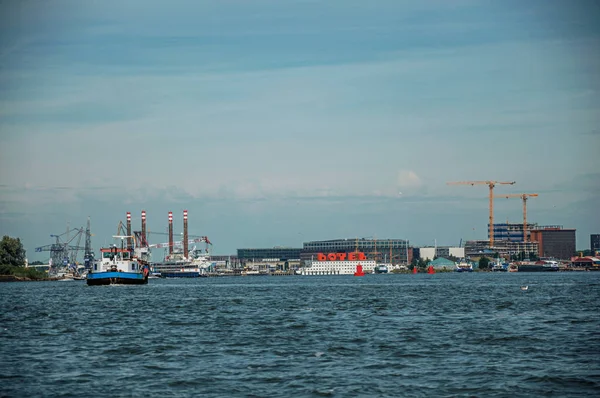 Порт и лодка с современными зданиями в канале Амстердама — стоковое фото