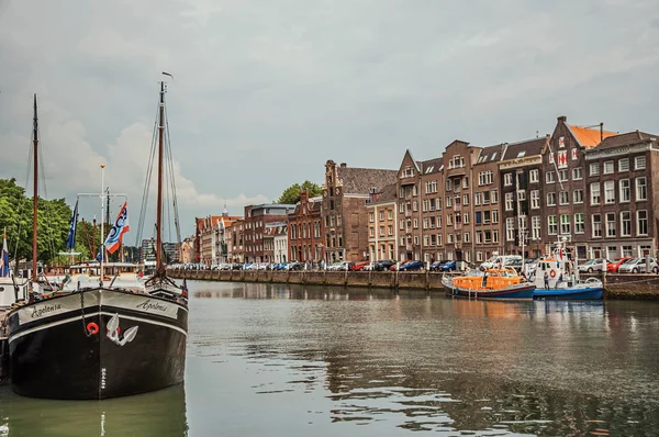 Canal com construção de tijolos velhos e barcos ancorados em Dordrecht — Fotografia de Stock