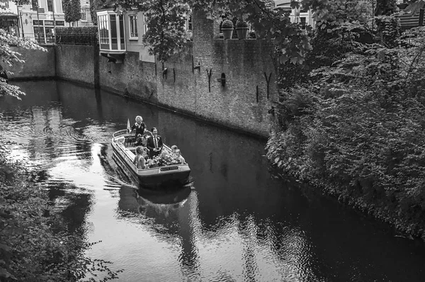Barco com pessoas navegando canal e vegetação exuberante — Fotografia de Stock
