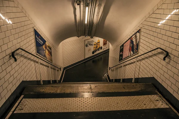 Реклама и лестницы в проходе в парижском метро — стоковое фото