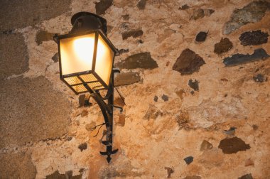 Eski tarz metal sconce caceres alacakaranlıkta taş duvar ve yumuşak ışık sıkışmış