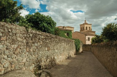 Santa Maria la Mayor Kilisesi ve Trujillo de çan kulesi doğru gidiyor taş duvarları ile bulutlu bir günde Alley.