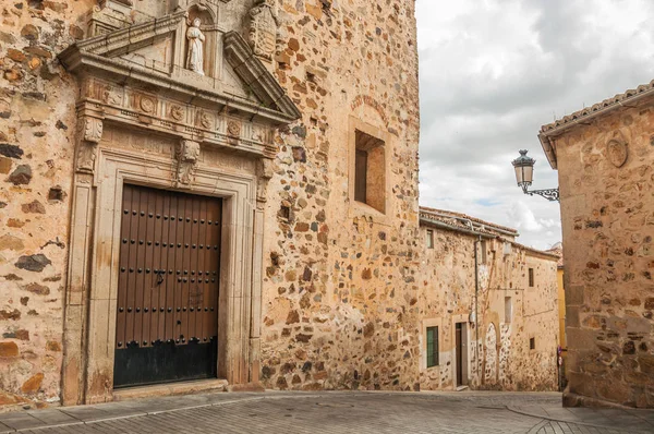 Verlaten straat met houten deur en gotische gebouwen in bewolkte dag in Caceres — Stockfoto