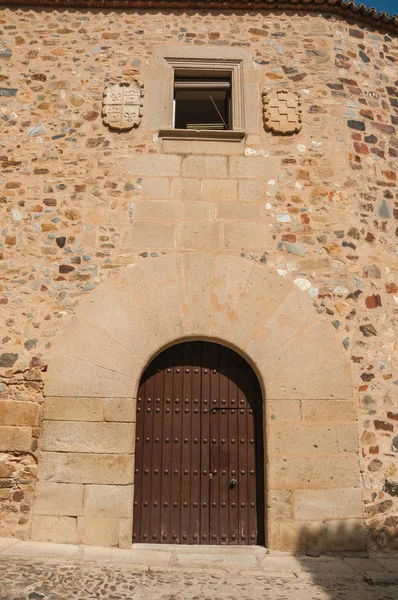 Дерев'яні двері на старому фасаді будівлі з закругленим верхом в Caceres — стокове фото