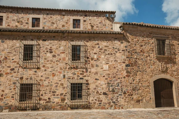 Fachada do edifício medieval, com porta de madeira e janelas barradas em Cáceres — Fotografia de Stock