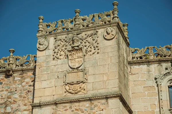Family crest sculpture on stone tower at Caceres
