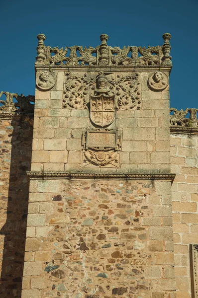 Family crest sculpture on stone tower at Caceres