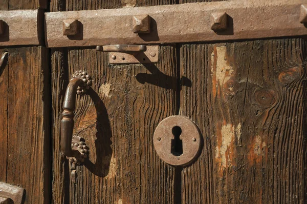 Ściągacz żelaza, otwór na klucze i stadnina w starych drewnianych drzwiach w Caceres — Zdjęcie stockowe
