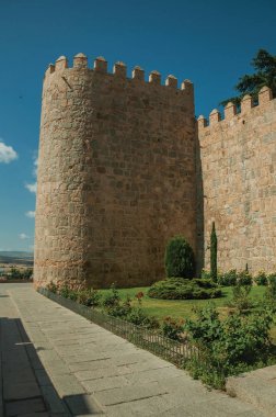 Avila'da yeşil bahçenin yanındaki duvarda kule