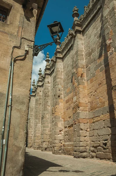 Stone side wall of gothic cathedral on empty alley at Avila