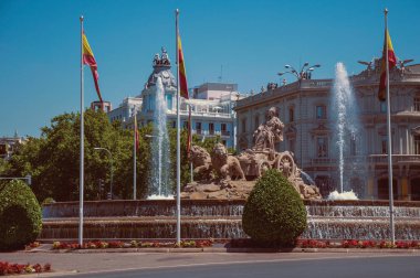 Madrid'de İspanyol bayrakları ve eski binalar ile Cybele çeşme