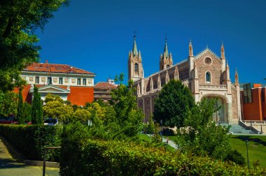 Madrid Katedrali önünde bahçede yapraklı ağaçlar ve çim