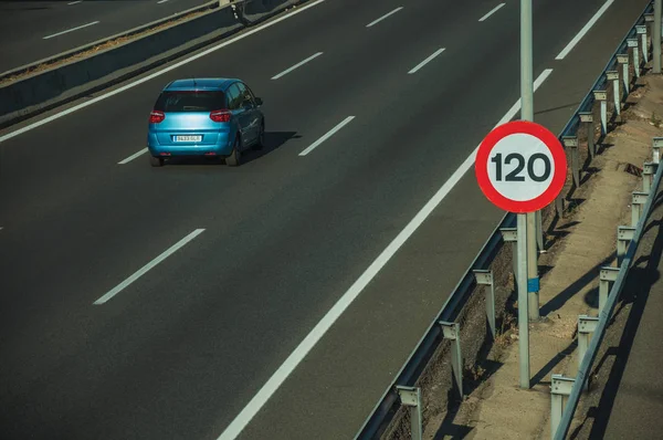 stock image Lonely blue car on highway and SPEED LIMIT signpost in Madrid