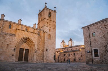 Caceres'te gotik kilise, binalar ve insanlar ile Arnavut kaldırımlı kare