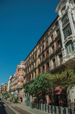 Madrid'in işlek bir caddesinde dükkanlar ve insanlar ile eski binalar