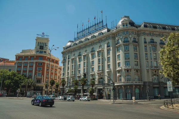 Edificios con hotel en calle concurrida con gente y coches en Madrid — Foto de Stock