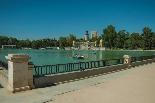 Gente remando botes en la piscina en un parque de Madrid — Foto de Stock