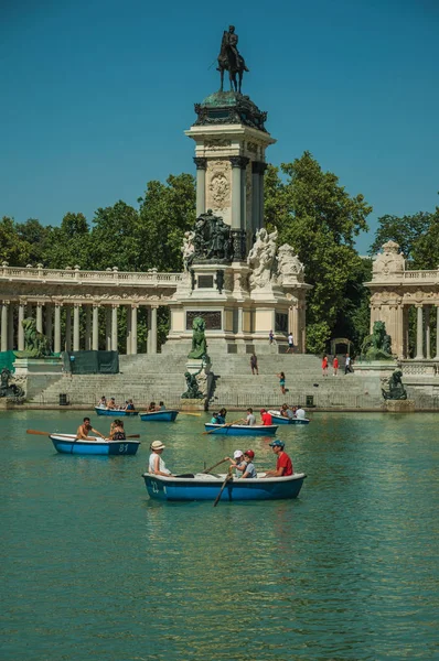 Pessoas com barcos na piscina em frente ao monumento em um parque de Madrid — Fotografia de Stock