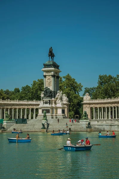 Pessoas com barcos na piscina em frente ao monumento em um parque de Madrid — Fotografia de Stock