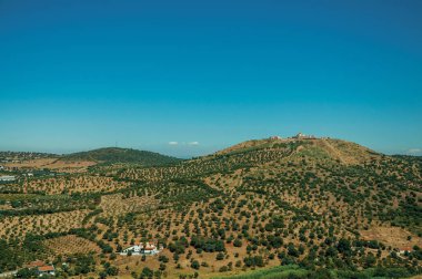 Tepe ve küçük çiftliklerin üstünde kale ile Peyzaj