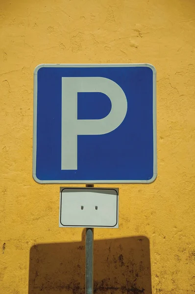 Parkplatzschild vor gelber Wand — Stockfoto