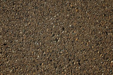 Asfaltın içine çakıl takılı yakın çekim