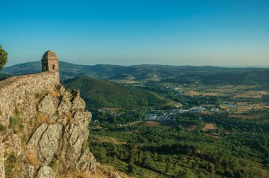 Küçük gözetleme kulesi ve dağlık manzara ile uçurum üzerinde taş duvar