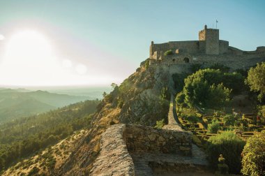 Yemyeşil çiçekli bahçeli taş duvarlar ve kale kulesi