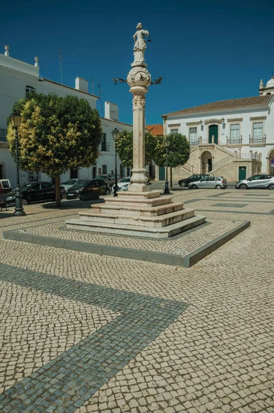 Eski binalar ile ıssız meydanda Mermer pillory