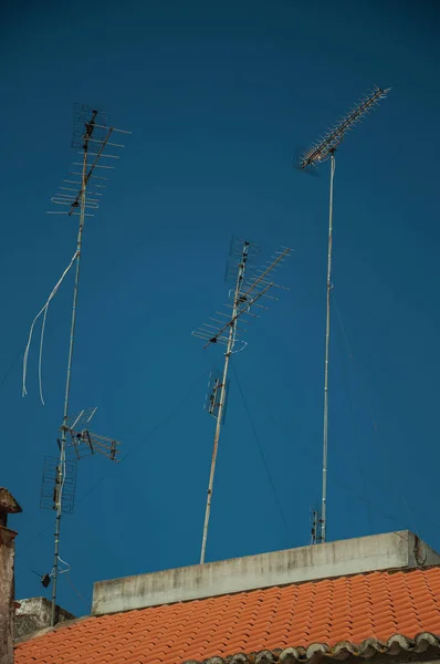 Mavi gökyüzü ile çatı üstünde televizyon antenleri seti — Stok fotoğraf