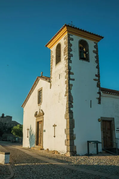 Parede caiada na igreja velha com campanário e porta de madeira — Fotografia de Stock