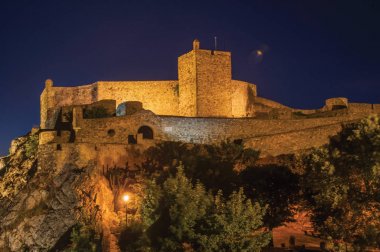 Marvao'da alacakaranlıkta kayalık uçurumun üzerinde Kale duvarları ve kulesi