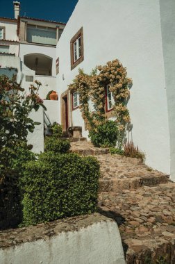 Merdivenlerile arnavut kaldırımlı sokakta eski ev ve çiçekli pencere