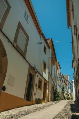 Yamaç üzerinde Arnavut kaldırımlı sokakta eski renkli evler