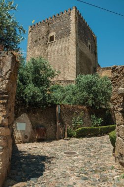 Taş duvar ve kuleye doğru giden parke taşı yolu