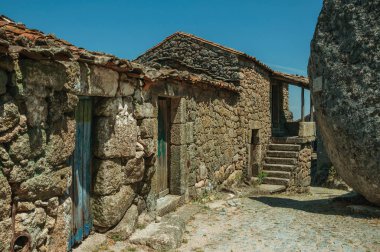 Monsanto taş duvar ve büyük yuvarlak kaya ile eski evler