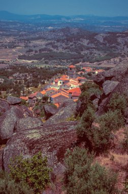 Monsanto'da ağaçlar ve kayalarla kaplı engebeli manzara