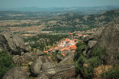Monsanto'da ağaçlar ve kayalarla kaplı engebeli manzara