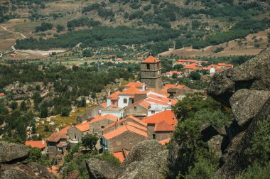 Monsanto'da ağaçlar ve kayalarla kaplı engebeli manzara