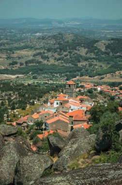 Monsanto'da ağaçlar ve kayalarla kaplı engebeli manzara