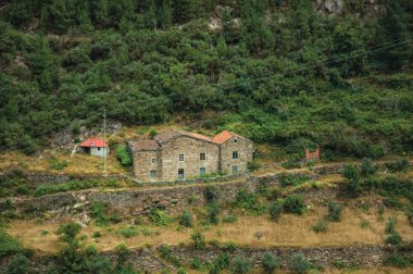 Rustik bir kır evi ile tepelik peyzaj ve teraslı alanlar