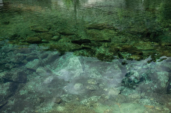 Água cristalina em pequena lagoa com pedras no fundo — Fotografia de Stock