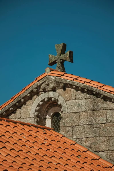 Черепица на крыше средневековой часовни и каменный крест — стоковое фото
