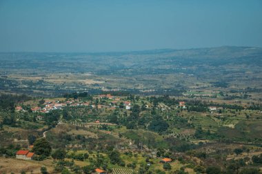 Ağaçlar ve yazlık çatılar ile kırsal manzara